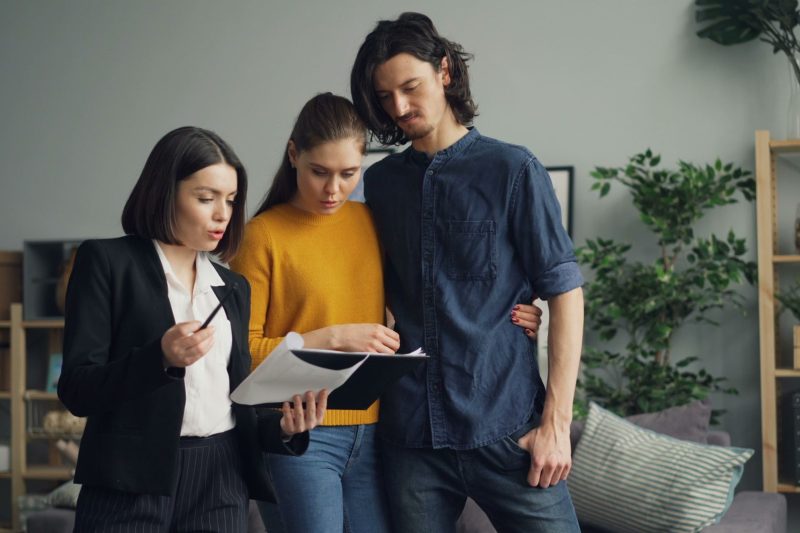 Home 2 A couple reviewing documents with a real estate agent indoor 1781629493
